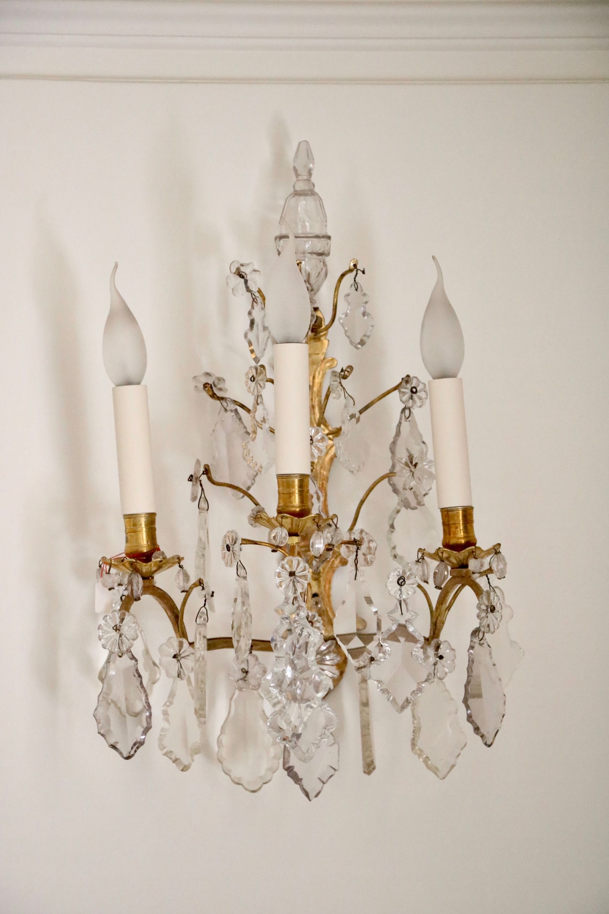 Paire d’appliques à trois bras de lumières en cristal et en bronze doré
